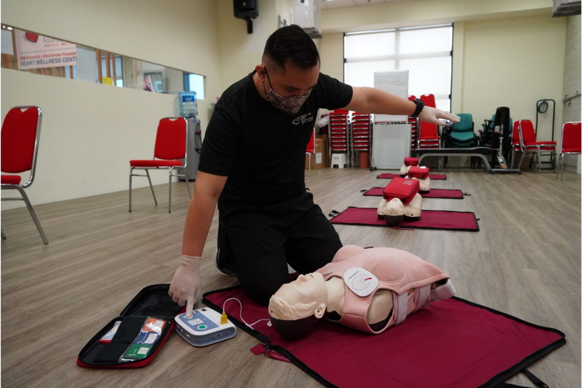 Person performing CPR and AED on a female manikin
