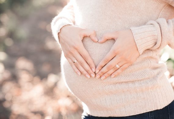 Pregnant woman with hands forming a heart