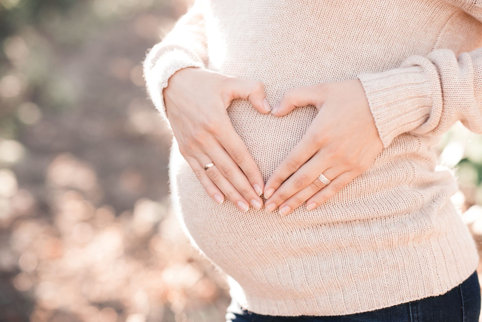 Pregnant woman with hands forming a heart