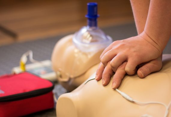 Person performing CPR and AED on a manikin