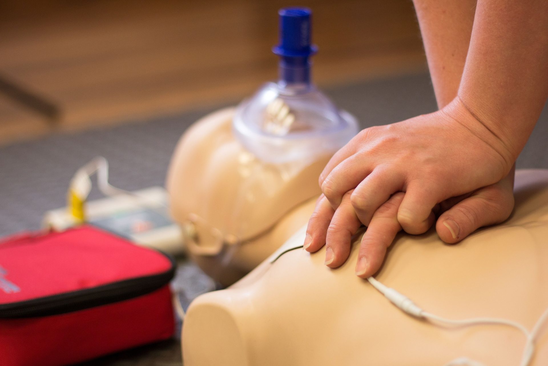 Person performing CPR and AED on a manikin