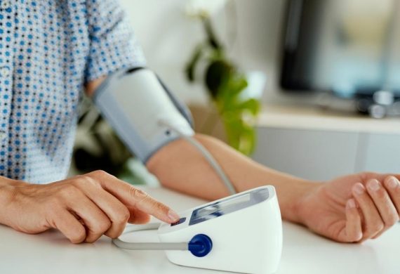 Person measuring blood pressure at home