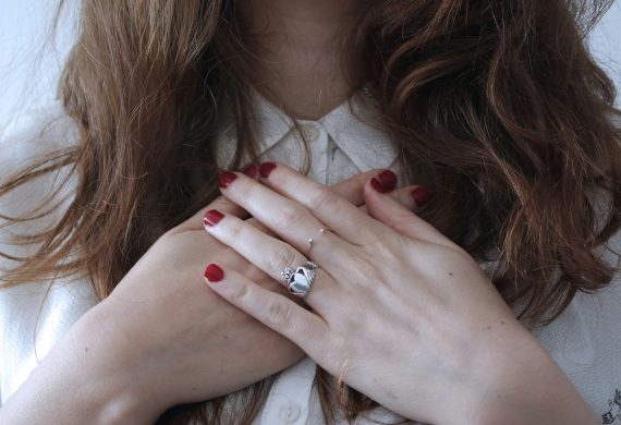 Woman with hands clasped on chest