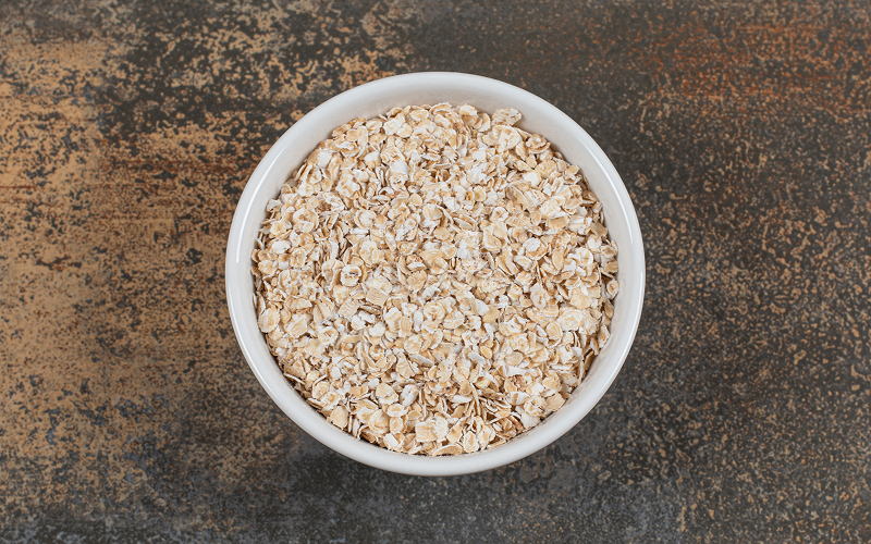 Bowl of raw oats, a high-fiber food for HDL cholesterol.
