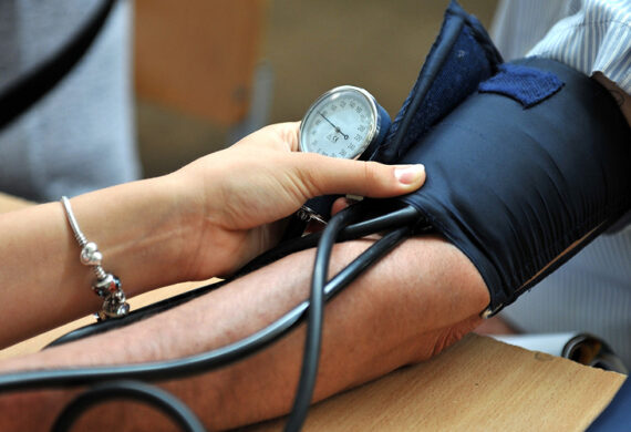 Medical professional conducting a blood pressure check for a patient.