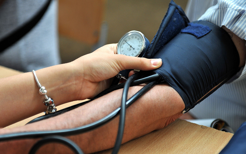 Medical professional conducting a blood pressure check for a patient.