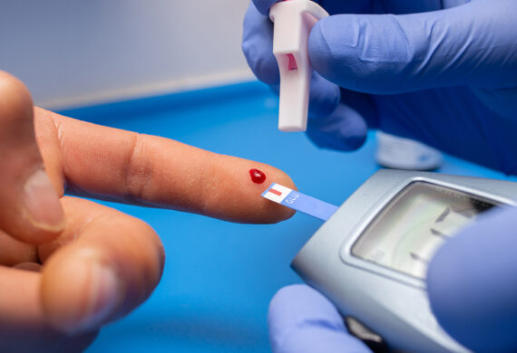 Monitoring blood glucose levels with a finger prick test.