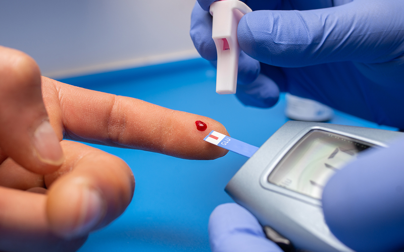 Monitoring blood glucose levels with a finger prick test.