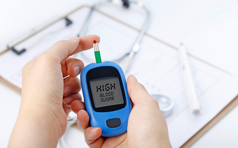 Person checking high blood sugar levels with glucose monitor.