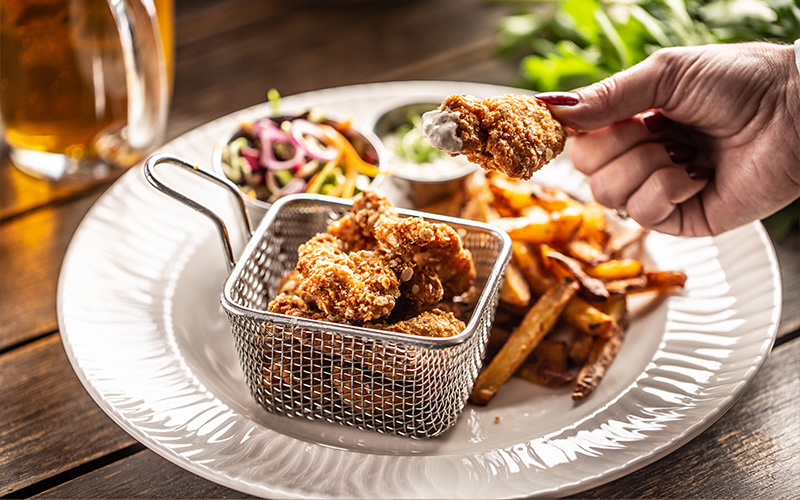 Plate with fried chicken, fries, salad, and sauce.