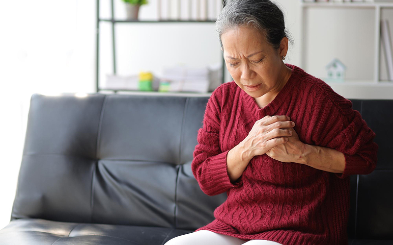 Elderly woman suffering from chest tightness, a heart failure warning.