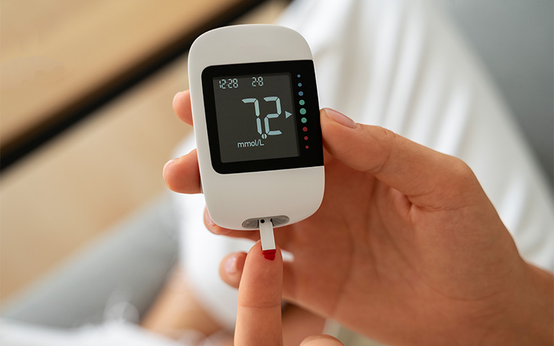 Patient using a glucose meter to monitor diabetes levels.