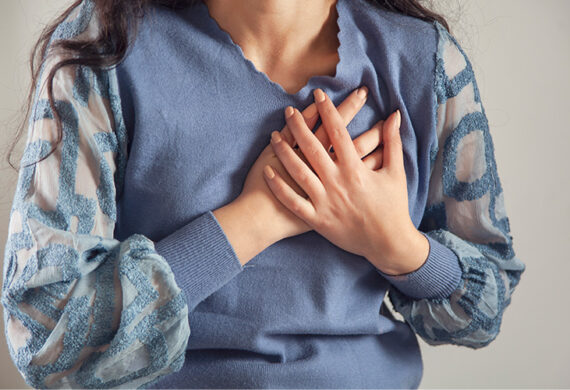 Person holding chest with interlaced hands.