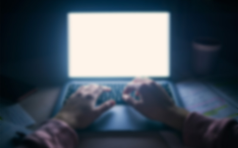 Blurry view of laptop screen at night.