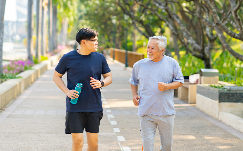 Two Singaporean men jogging together outside.