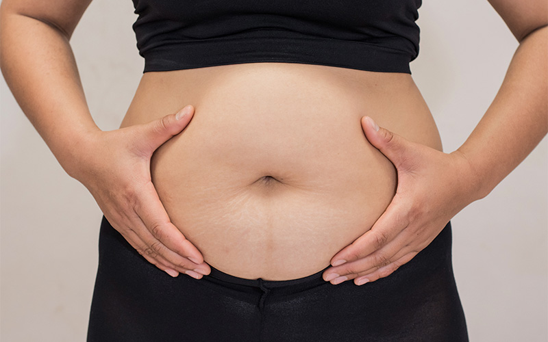 Person holding abdomen with both hands.
