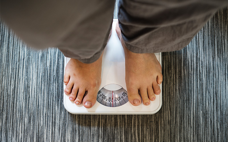 Person standing on an analog bathroom scale.