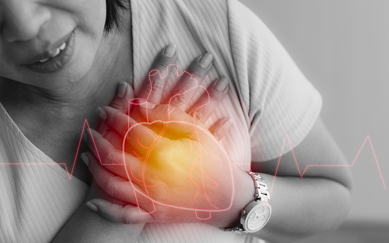 Woman clutching chest experiencing painful symptoms of first-degree heart block.